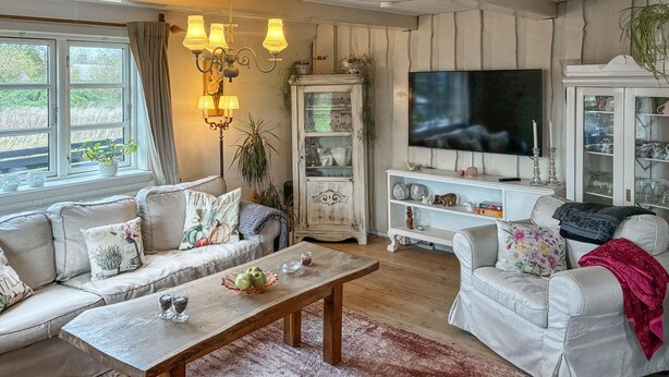 A living room with a sofa, a coffee table, a cabinet, and a TV. - Beautiful home in Stege with WiFi (Stege)