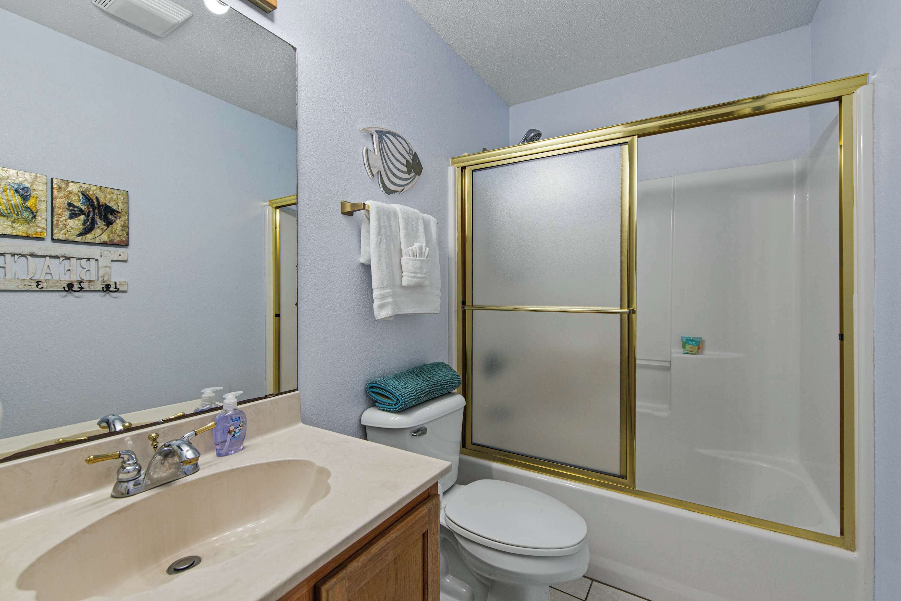 A bathroom with a sink, toilet, and a shower with a glass door.