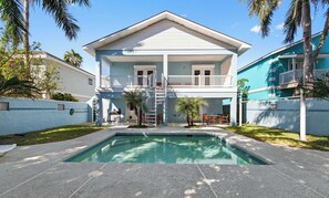 Una casa a due piani con piscina, un balcone e un garage.