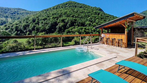 A pool area with a wooden deck, a bar, and a view of a forested mountain. - Paradise lost swimming pool jacuzzi billiards table soccer... (Louvie-Juzon)