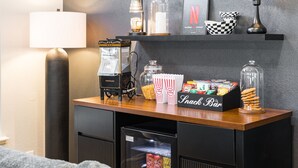 En servering som säljer snacks som popcorn, godis och kakor, en gammal popcornmaskin och en neonreklamskylt.