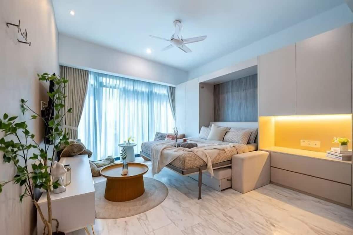 Ein modernes Schlafzimmer mit Bett, Nachttisch und Deckenventilator.