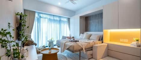 Un dormitorio moderno con cama, mesita de noche y ventilador de techo.