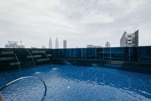 A rooftop swimming pool with a city skyline view. - EATON BY FEEL HOME (Kuala Lumpur)