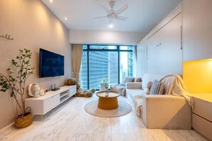 A modern living room with a flat-screen TV, a round coffee table, a sofa, and a TV stand. - EATON BY FEEL HOME (Kuala Lumpur)