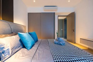 A modern bedroom with a bed, pillows, a patterned rug, and a wardrobe. - EATON BY FEEL HOME (Kuala Lumpur)