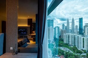 A modern hotel room with a large window, a bed, a TV, and a city view. - EATON BY FEEL HOME (Kuala Lumpur)