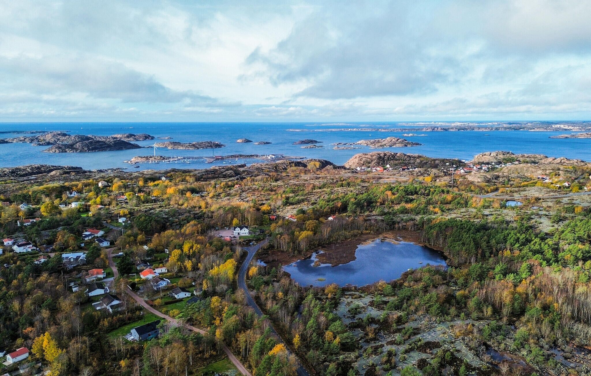 Un village côtier avec des maisons, un petit lac et un paysage rocheux.