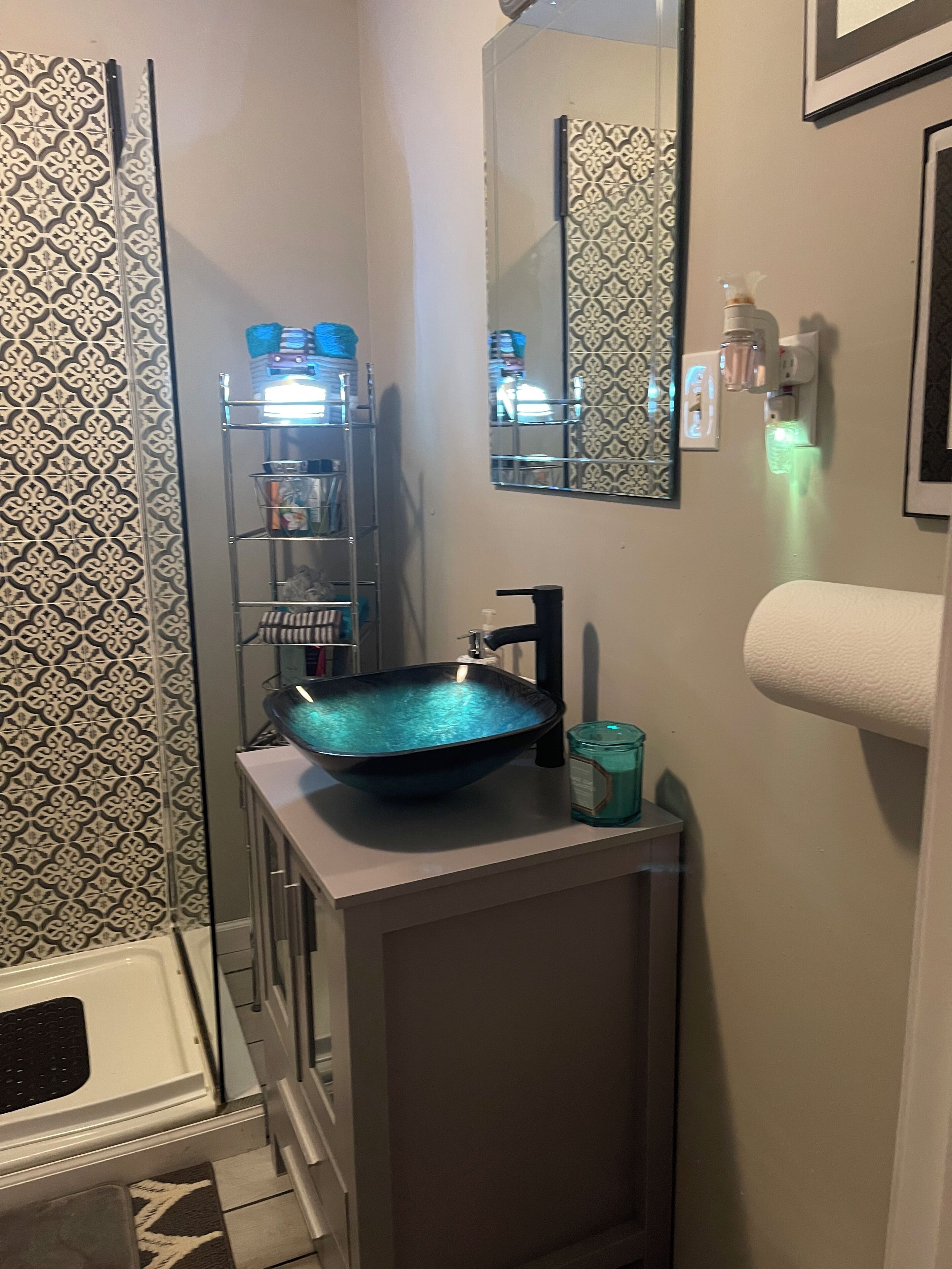 Une salle de bain dotée d’un lavabo moderne, d’une douche à parois de verre et de toilettes.