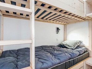 Ein Stockbett mit einem hölzernen Kopfteil und einem Bett darunter.