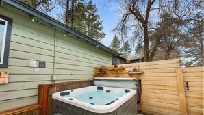 Ein Whirlpool in einem Hinterhof mit Holzzaun und einem Haus im Hintergrund.