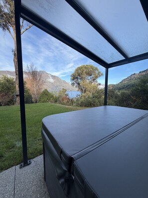 A covered outdoor seating area with a view of a lake and mountains. - Arawata Alpine Views - 2BDRM luxury (Queenstown)