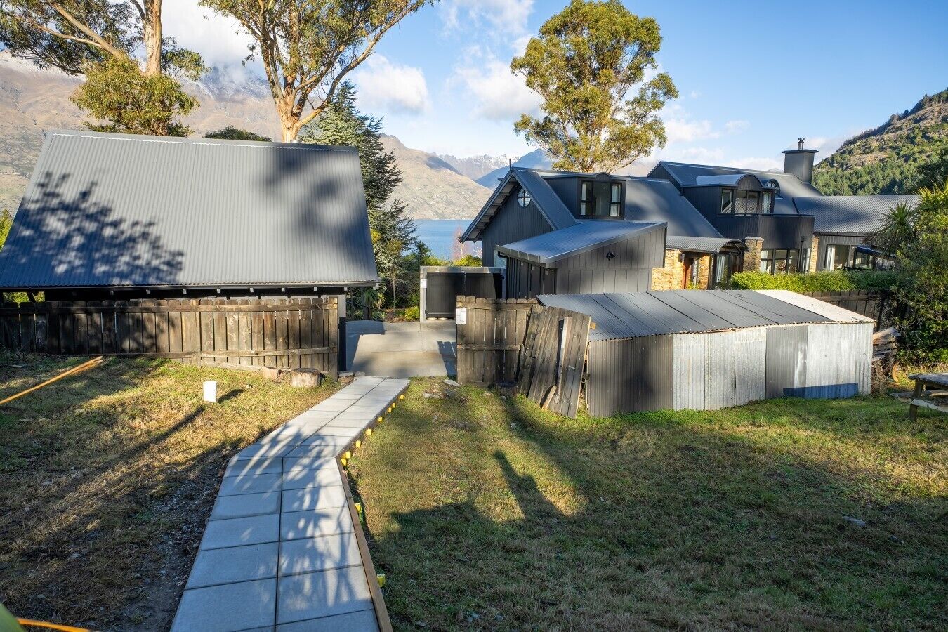 A residential property with a large house, a smaller attached structure, and a fenced yard.