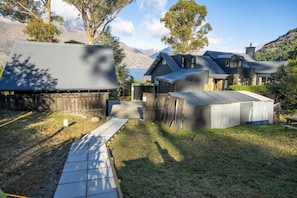 Uma propriedade residencial com uma casa grande, uma estrutura menor anexa e um quintal cercado.