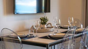 A dining table set with clear glassware, plates, and cutlery, with a woven basket and a small plant on the table. - Arawata Alpine Views - 2BDRM luxury (Queenstown)