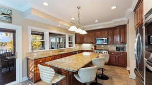A spacious kitchen with granite countertops, stainless steel appliances, and a large island with bar stools. - Lake Norman Retreat w/ Pool, Hot Tub & Private Dock Lake Life Cove by Avantstay (Mooresville)
