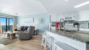 Een moderne keuken met witte kasten, een granieten werkblad en een roestvrijstalen spoelbak.