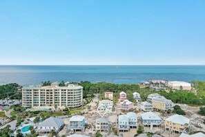 A coastal resort with beachfront properties, a large hotel, and a swimming pool. - Steps to Beach | Community Pool & Hot Tub | Spacious Family Retreat | BEACHBALL PROPERTIES (Gulf Shores)
