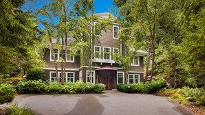 A two-story house with a front entrance, surrounded by lush greenery and trees. - Experience luxury at Thorne Swift Lakehouse, Harbor Springs - Lake Michigan (Harbor Springs)