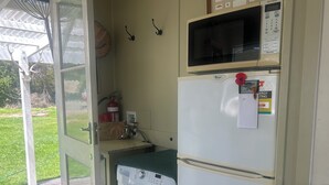 Un lavadero pequeño equipado con lavadora, microondas y refrigerador.