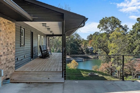 A covered porch with a view of a river and trees.. Sunset Ridge on Lake Keowee!