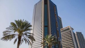 A tall, modern skyscraper with a unique architectural design, featuring two prominent spires. - Blueground | DIFC, rooftop pool, nr Burj Khalifa (Dubai)