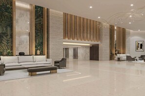 Eine großzügige Lobby im modernen Stil, mit einem weißen Sofa, einem Couchtisch und einer Sitzecke mit Sesseln.
