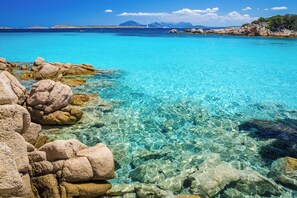 A clear turquoise sea with visible rocks and a distant mountain range. - Holiday apartment with sea view (Liscia di Vacca)