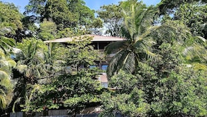 A tropical resort with a clear view of the water, lush greenery, and a building with a red roof. - Brisas del Mar Bocas (Bastimentos)