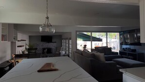 Ein stilvoller Wohnbereich mit Kücheninsel, Sitzgelegenheit und Kamin.