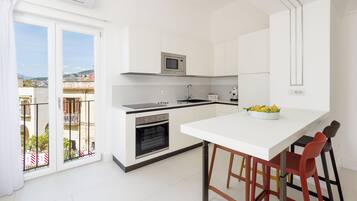 Appartamento Exclusive, vista mare parziale | Cucina privata | Frigorifero, forno, piano cottura, macchina per caffè espresso