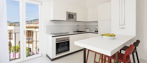 Una cocina moderna con horno empotrado, microondas y una isla grande con taburetes de bar.