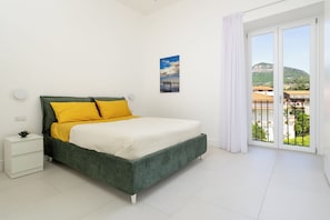 Appartamento Deluxe, vista giardino | Copriletto in piuma, una scrivania, postazione laptop, tende oscuranti