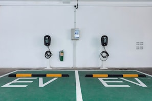 Une borne de recharge pour véhicules électriques dotée de deux points de recharge, d’un extincteur et d’un panneau de commande.