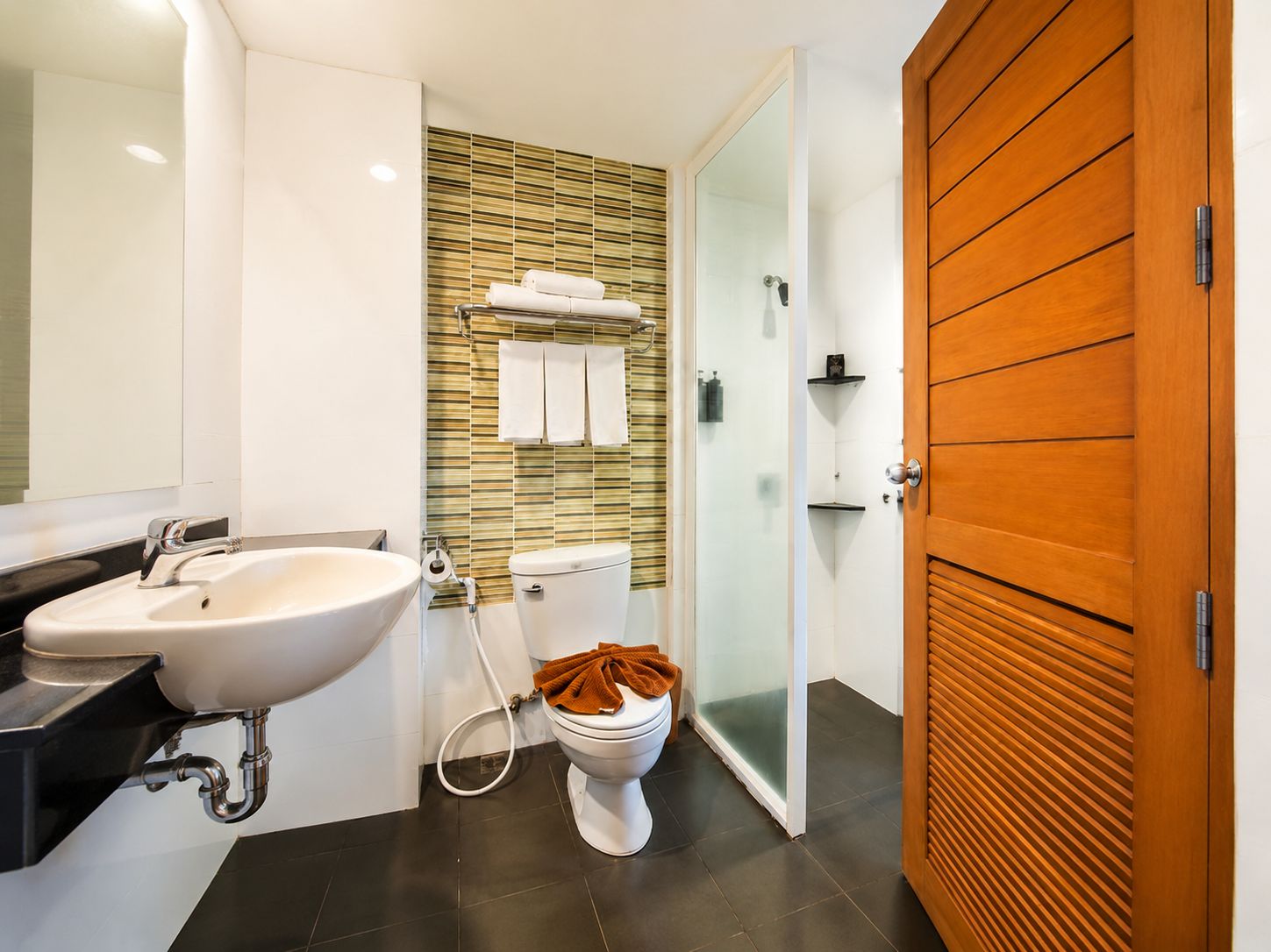 Ein modernes Badezimmer mit Waschbecken, Toilette und Duschkabine aus Glas.