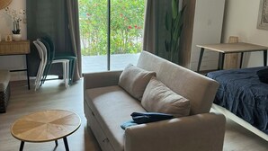 A modern living room with a sofa, a round table, and a bed. - Bora bora studio vacation (Bora-Bora)