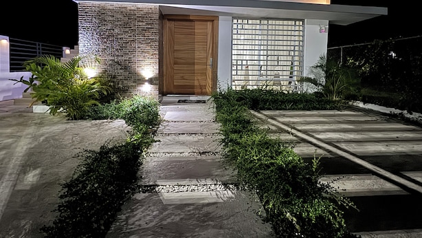 A modern house with a stone facade, a wooden door, and a glass window. - Welcome to Casa Cangrejo, your perfect escape in Puerto Plata, DR (Sosúa)