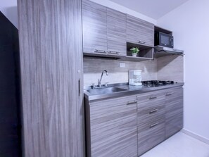 Microondas, placa de cocina, cafetera o tetera y utensilios de cocina