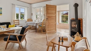 Une pièce chaleureuse avec un plancher en bois, une table à manger avec des chaises, un canapé et une cheminée.