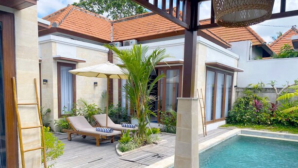 Ein Poolbereich mit Liegestühlen, einer Holzterrasse und einem kleinen Pool.