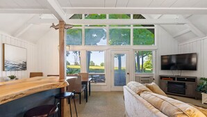 A spacious room with a wooden bar, a sofa, and a TV. - Indian Lake, Lucky 7 Chalet (Central City)