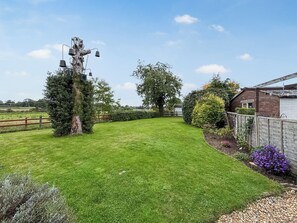A well-maintained lawn with a wooden fence, a large tree, and a small shed. - 2 bedroom accommodation in Hinton, Market Drayton. (Hinton, Market Drayton.)