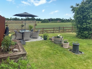 A backyard with a patio, outdoor furniture, and potted plants. - 2 bedroom accommodation in Hinton, Market Drayton. (Hinton, Market Drayton.)