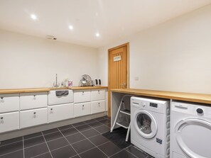 A laundry room with a washing machine, a dryer, a wooden shelf, and a door labeled 'Laundry.' - 6 bedroom accommodation in Llandevaud (Llandevaud)