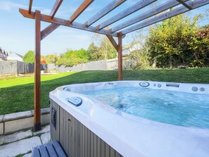 A hot tub under a wooden pergola in a backyard. - 6 bedroom accommodation in Llandevaud (Llandevaud)