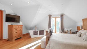 A bedroom with a bed, a wooden dresser, a TV, a small table with chairs, and a window with curtains. - 6 bedroom accommodation in Llandevaud (Llandevaud)