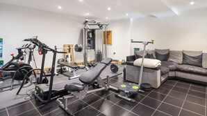 A home gym with exercise equipment, a couch, and a tiled floor. - 6 bedroom accommodation in Llandevaud (Llandevaud)