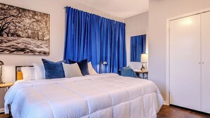 A bedroom with a large bed, a desk with a chair, a lamp, and a wardrobe. - The Montrose City-Chic Den, Near Medical Center (Houston)