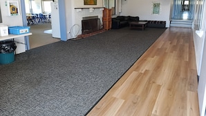 En rummelig stue med pejs, sofa, sofabord og tæppe.