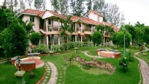 Un hotel con un patio central rodeado de abundante vegetación y una piscina.